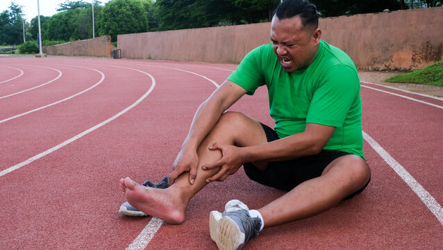 Young adult male with his muscle pain during running. runner man having leg ache due to Shin Splints. Sports injuries and medical concept