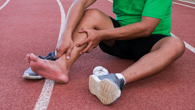 Young adult male with his muscle pain during running. runner man having leg ache due to Shin Splints. Sports injuries and medical concept
