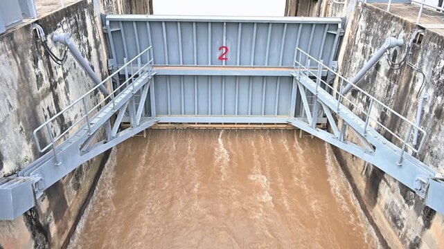 Spillway of Chiang Rai dam open for release water. Spillway, passage for surplus water over or around a dam when the reservoir itself is full.