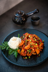 Spicy Seafood Stir-fry with Vermicelli Noodles on a Dark Plate