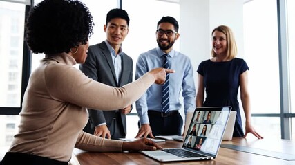 Diverse business team having a video conference on a laptop in a modern office. Collaborative hybrid meeting concept suitable for corporate communication and technology visuals. - Powered by Adobe