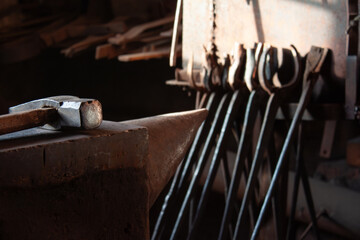 hammer on anvil in rustic blacksmith shop start of workday