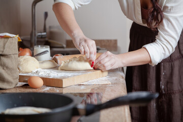 woman uses her fingers to seal seam on unfried pie