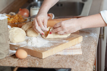 Woman hands connect the halves of a raw pie