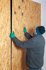 Man with beard sets up large wooden sheet