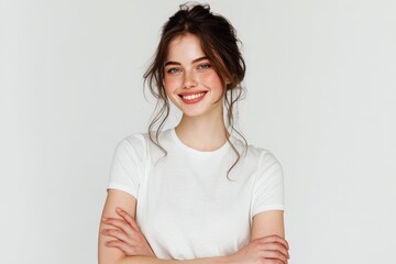 Fototapeta premium Natural portrait of a beautiful girl with a radiant smile in a simple white shirt against a clean background during soft daylight