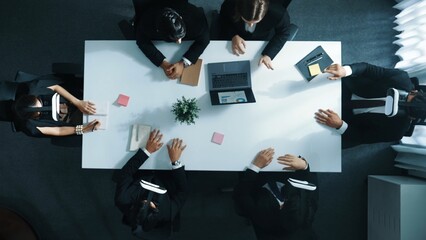 Top down aerial view of professional business team wear vr headset and receive financial data from laptop while use hand gesture to control marketing plan from manager laptop at meeting. Directorate.