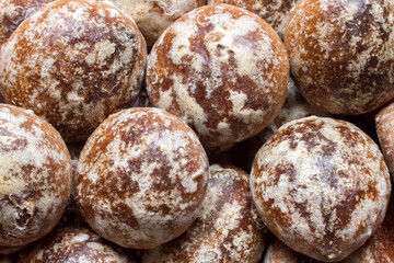 A lot of round gingerbread with glaze. Small brown gingerbread close-up