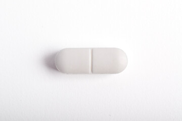 White medicine Tablet pill on a blue white background. Top view, flat lay.