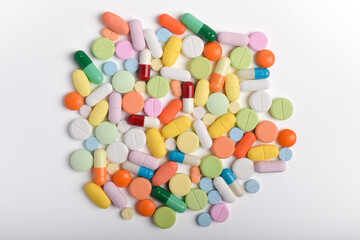 Various colorful pills and capsules on white background, displaying various medicines, vitamins and supplements for healthcare and pharmacy concept.