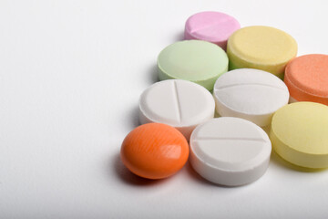 Various colorful pills on white background, displaying various medicines, vitamins and supplements...