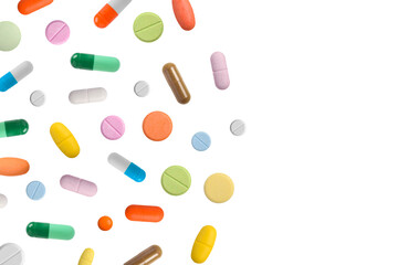 Various colorful pills and capsules form a frame, isolated on a white background, copy space for text. Medical concept.