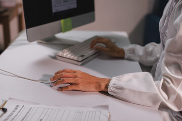 Person using computer, working with mouse and keyboard