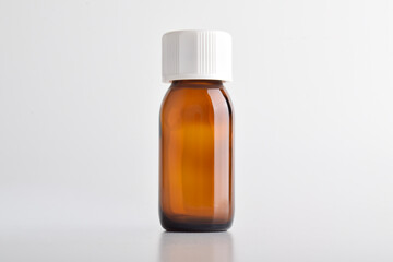 Brown glass bottle with white cap isolated on white background.