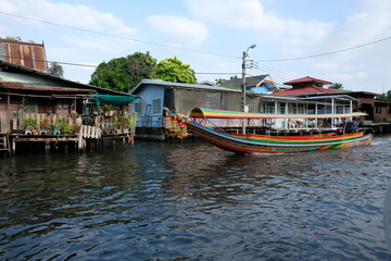 Obraz premium Colorful longtail boat cruising on a canal in Bangkok, Thailand
