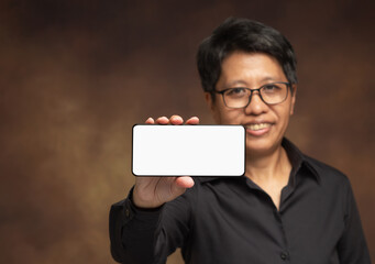 Androgynous woman showing blank smartphone for gender diversity concept.