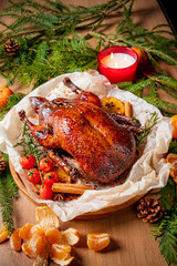 Roasted duck rests on herbs with citrus and candles, creating a warm atmosphere