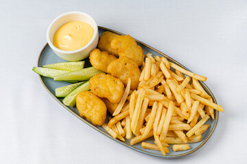 Tender fried nuggets, perfectly golden and crunchy, served with crispy fries and a creamy dip