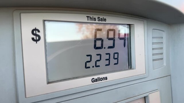 Screen of a gas pump showing the digital numbers going up in price as customer pumps fuel video clip has an authentic handheld vibe.