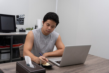 Man freelance working at home on laptop computer.
