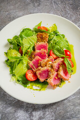 Seared tuna on fresh greens and tomatoes offers a vibrant burst of flavor