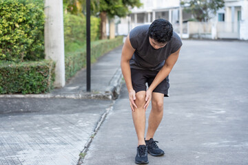 Fototapeta premium Man leg pain during jogging, sore knees because he has been running for too long.