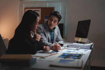 Business colleagues discussing data working together late night
