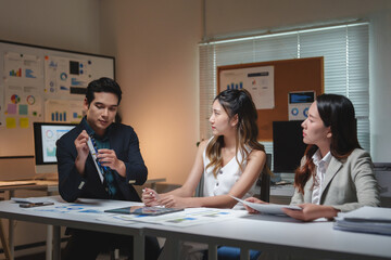 Business professionals discussing financial data during late night meeting