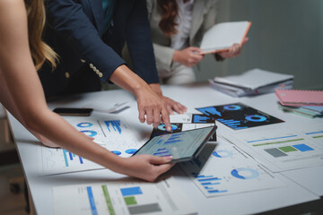 Business professionals analyzing financial data using tablet and charts