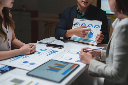 Business professionals analyzing marketing data during a meeting - Powered by Adobe