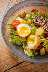 Fresh greens with soft-boiled eggs, seared tuna, and roasted potatoes make a vibrant dish