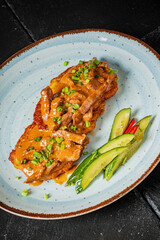 Tender beef topped with rich sauce, served with crunchy cucumber and herbs on a stylish plate