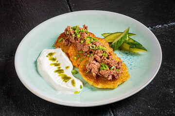Savor crispy flatbreads topped with tender beef and a side of yogurt and pickles, an inviting meal