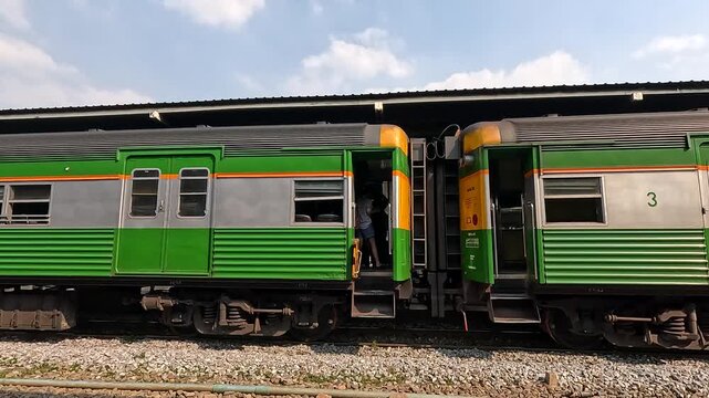 Green Passenger Train Departing Platform at Bangkok Rail Station