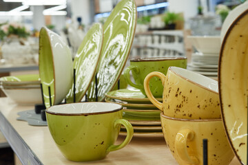Green and yellow cups, plates, ceramic dishes in the store