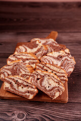 close-up view of deliciously baked marbled chocolate and vanilla bread slices artfully arranged on a wooden cutting board, set against a rich, textured wooden background, inviting, gourmet