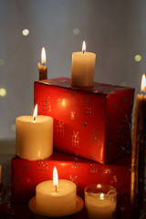 cozy holiday scene with lit candles on red-gift-wrapped presents in warm ambient glow and festive atmosphere with soft bokeh lights and intimate lighting, glowing, ornamental, wrapped, tender, homey
