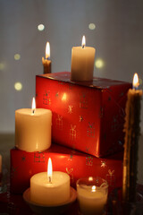 warm christmas ambiance with flickering candles and festive red wrapped gifts illuminated by soft glowing lights creating a cozy and tranquil holiday atmosphere, decorative, flames, white, serene