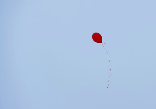 One red balloon on a string in the sky