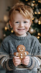 Cute little boy smiling and holding one gingerbread cookie