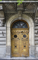 Highly decorated, weather-beaten old apartment building gate in Budapest