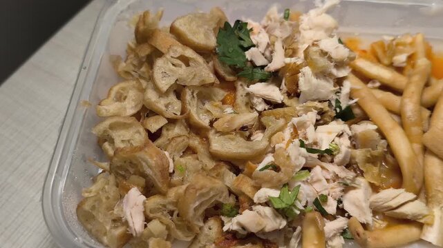 Close-up Video of Indonesian Bubur Ayam Toppings in Container
