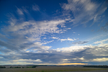 Fototapeta premium A Beautiful Sunset Sky Showcasing Dramatic Clouds Hovering Over a Serene Landscape