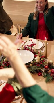 Stack of hands, christmas and family in home for dinner with bonding, unity or connection. Love, solidarity and top view of people with festive celebration together for xmas feast in dining room.