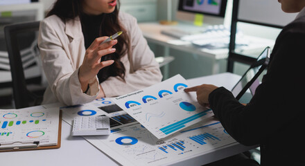 Business professionals analyzing financial data reports in office meeting
