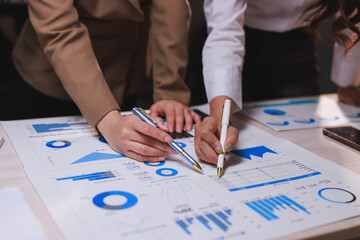 Businesswomen analyzing financial data, graphs during meeting