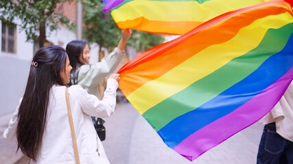 Young women celebrating diversity holding rainbow flags