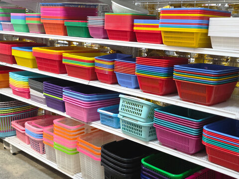 Colorful plastic container assortment on white shelf in store. An abundance of storage box products for sale providing many choices for household organization and feeling of order