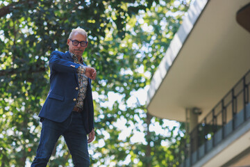 Stylish man checking time walking in urban setting