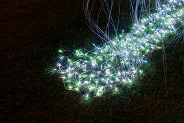 Magical glowing light decoration with green and white color for festive celebration at night. abstract background with bokeh effect and fiber optic creates an enchanting holiday display